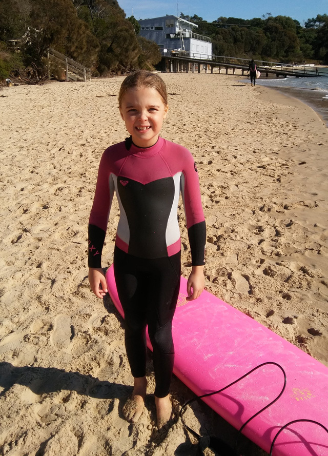 Beginner Surfer Beginner surfer with matching wetsuit and surfboard